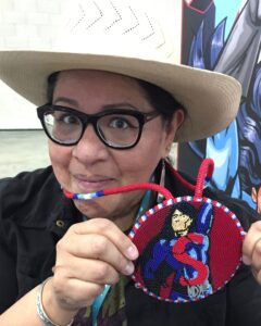 Arigon Starr with a beaded medallion featuring her character Super Indian